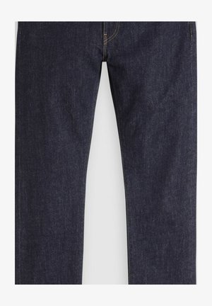 Tummansiniset suorat farkut, joissa näkyvät ompeleet ja napillinen vyötärö, valkoisella taustalla.