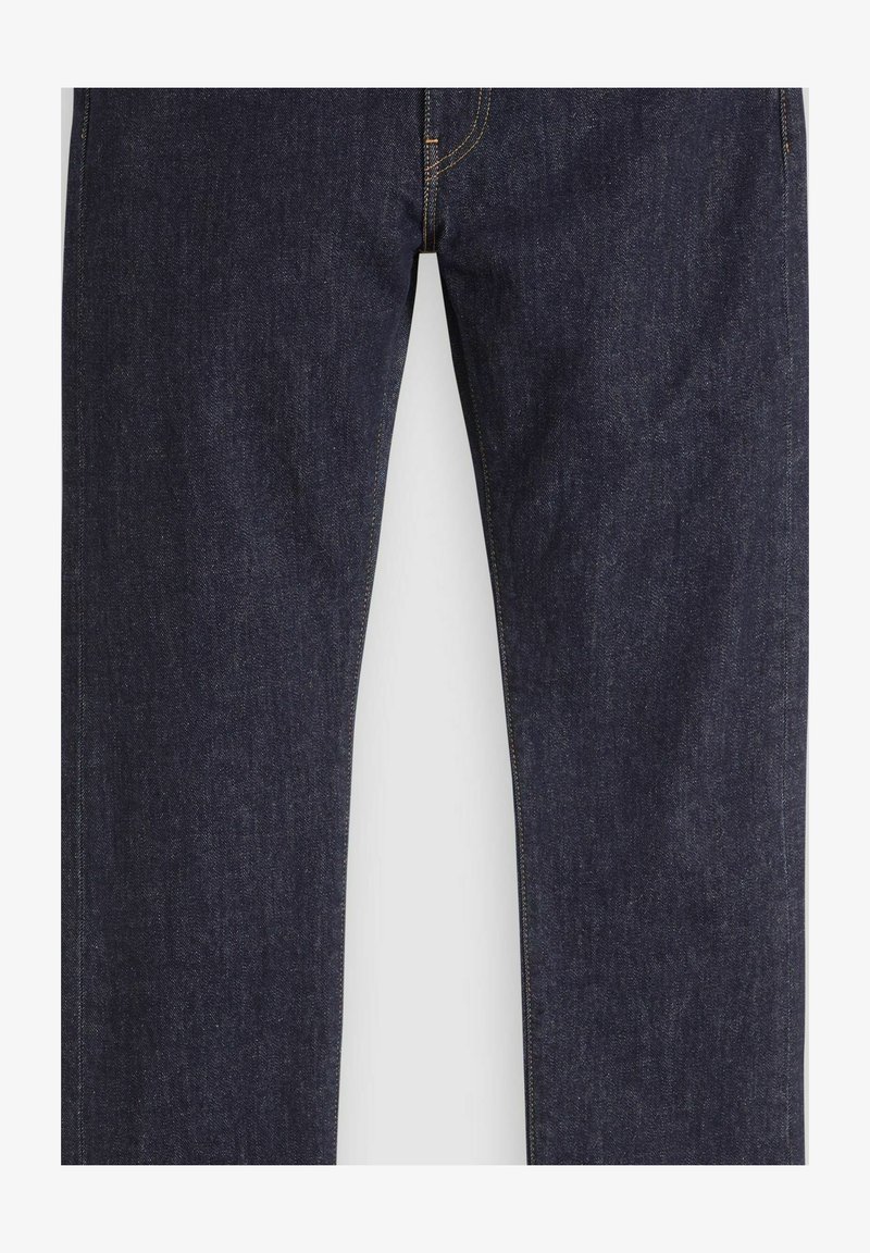 Vaqueros de mezclilla azul oscuro de pierna recta con costuras visibles y cierre de botón en la cintura sobre un fondo blanco.