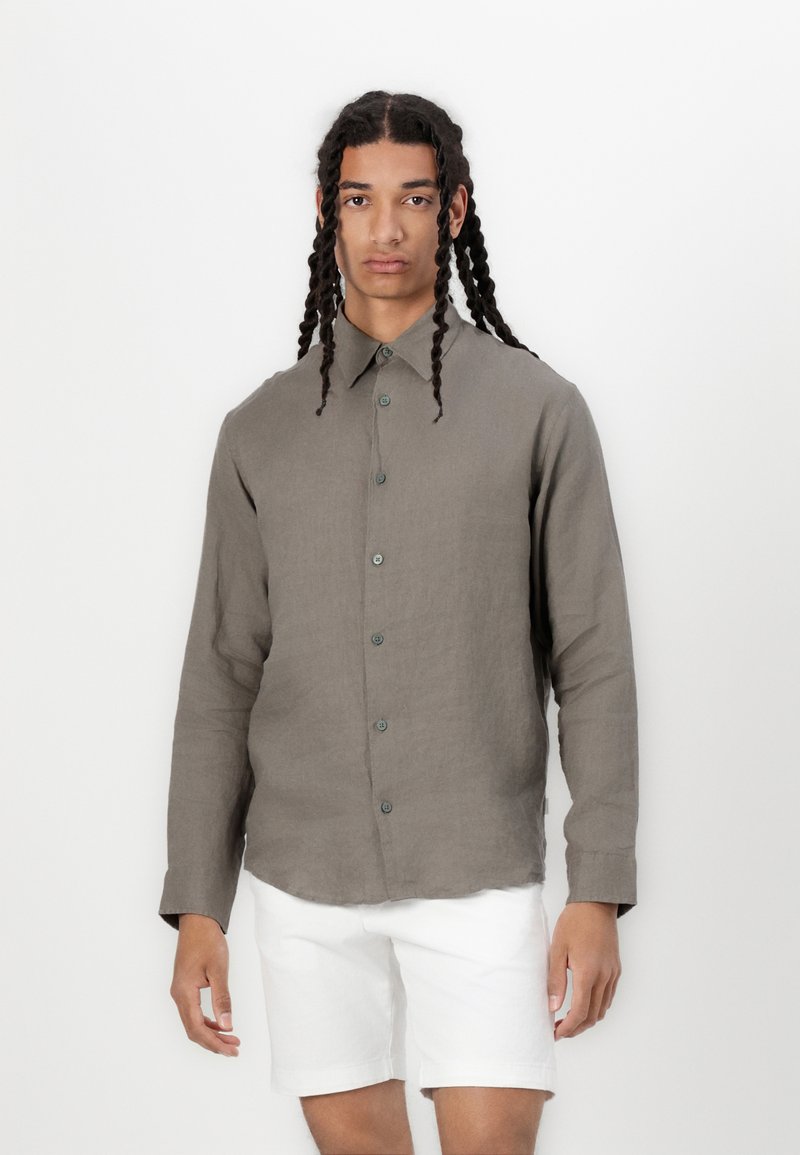 Camisa de lino ligera de color gris marrón con botones en la parte delantera, cuello puntiagudo y mangas largas. Textura suave, con botones verdes.