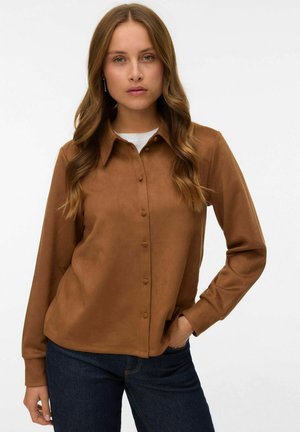 Brown, button-up shirt made of soft material with a collar and long sleeves, paired with dark jeans. Simple design with no patterns.