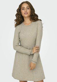 Robe tricotée en gris clair avec une texture côtelée. Manches longues, col rond et jupe évasée. Matière douce avec des détails de motif subtils.