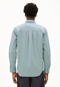 Lichtblauw, langemouwen shirt met een button-down kraag, rugplooien en verstelbare manchetten; gladde textuur en rechte onderkant.