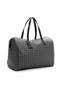 Sac de voyage gris et noir à motifs, avec deux poignées en cuir noir et fermeture à glissière, sur fond blanc.