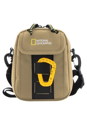 Beige Kameratasche aus Canvas mit gepolsterter Vorderseite, schwarzen Akzenten und einem gelben Karabinerhaken. Sie verfügt über verstellbare Träger und einen oberen Griff.