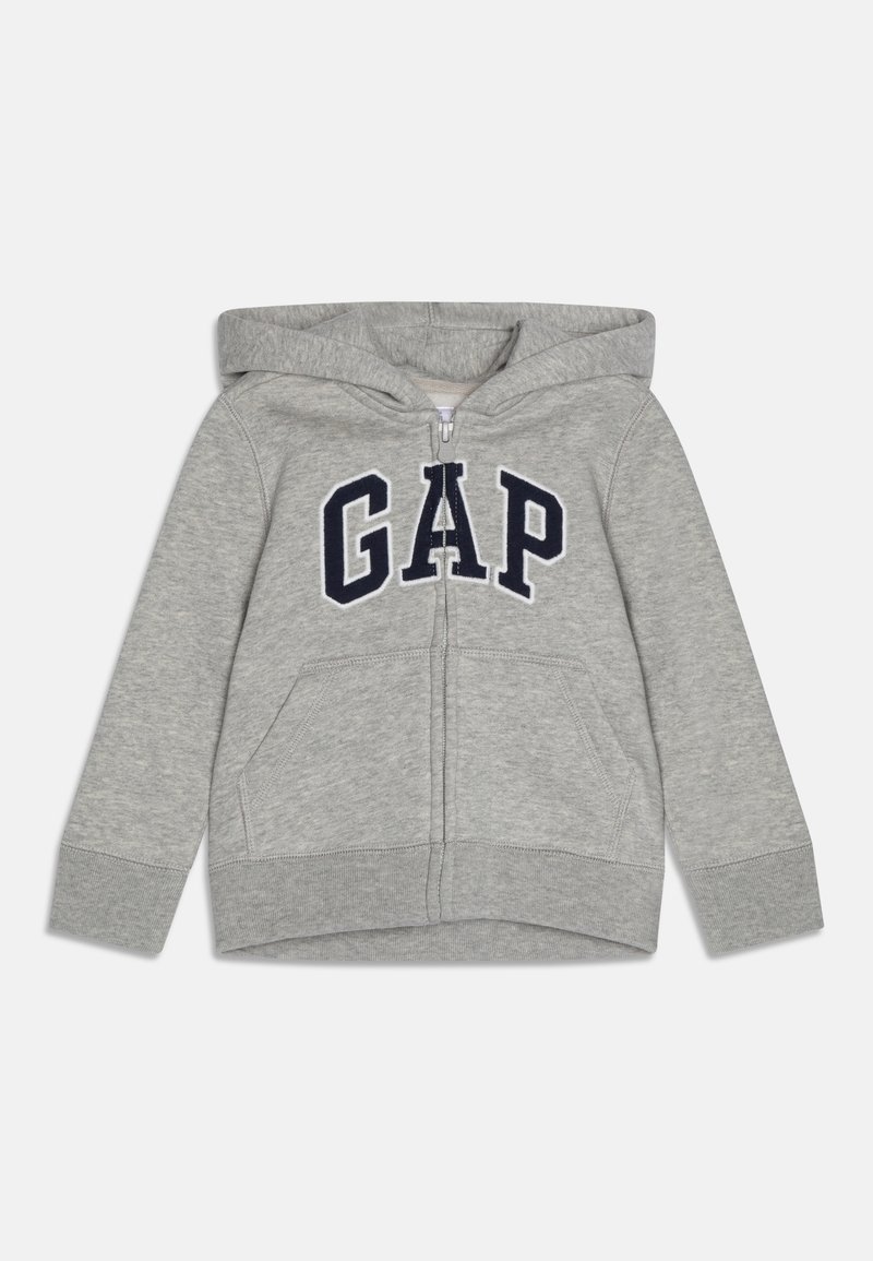 Sweat à capuche pour enfants gris clair avec fermeture éclair, poches avant, logo "GAP" bleu marine sur la poitrine et capuche attachée.