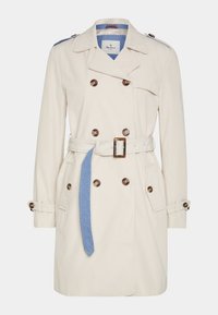 Béžový trenčkot vyrobený z bavlny s opaskem v pase, dvouřadým zapínáním, velkými bronzovými knoflíky a denimovými akcenty na pásku.