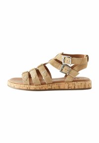 Beige zamšové sandály s několika pásky, dv�ěma stříbrnými přezkami a korkovou podrážkou. Plochý design pro každodenní nošení.