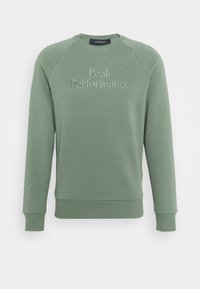 Sweat-shirt vert avec poignets et ourlet côtelés, arborant le logo brodé "Peak Performance" et la date de création 1936 sur le devant.
