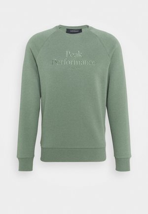Grön sweatshirt med ribbstickade muddar och fåll, med broderad "Peak Performance"-logotyp och etableringsdatum 1936 på framsidan.