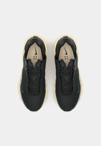 Tenisi sport negri cu un upper texturat, un design elegant și o talpă de o culoare deschisă, în contrast. Prezintă șireturi proeminente și perforații.
