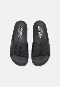 Black Adidas slides featuring a textured upper with three woven straps, rubber sole, and logo branding on the footbed.