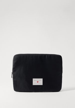 Black fabric laptop sleeve with a smooth texture. Features a silver logo label and a zip closure. Rectangular shape, minimalist design.