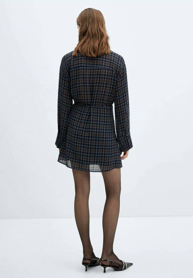 Abito camicia a quadri in blu scuro e nero, con maniche lunghe e vita cintrata. Tessuto trasparente con una texture leggera.