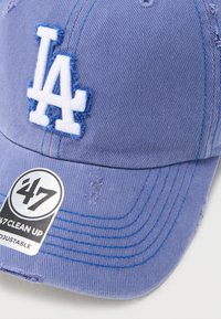 Ανοιχτό μοβ καπέλο μπέιζμπολ με λευκό λογότυπο "LA" και αυτοκόλλητο «47 Clean Up Adjustable» στη γείσο, με ελαφρώς φθαρμένες λεπτομέρειες.