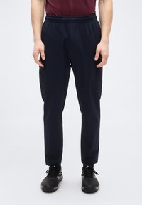 Μπλε ναυτικό παντελόνι cargo με ελαστική μέση, δύο πλαϊνές τσέπες και κωνικά πόδια, κατασκευασμένο από ελαφρύ, ελαστικό ύφασμα.