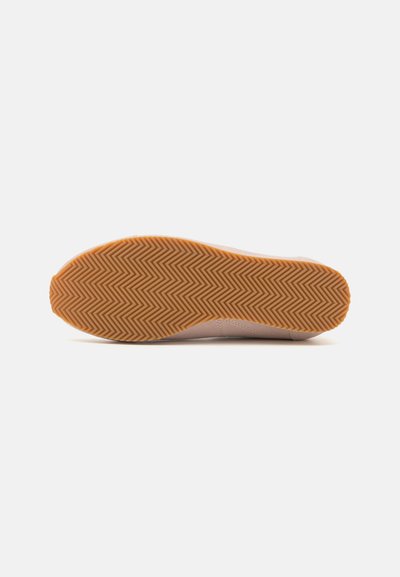 Lys rosa sneakersåle med gummiyttersåle som har et fiskebensmønster og rund tå. Glatt tekstur og minimale design-detaljer.