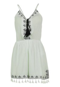 Robe sans manches vert clair avec des détails noirs brodés, un lien à pompons et un ourlet effiloché, présentant une taille cintrée et une jupe fluide.
