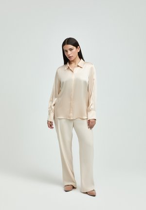 Satin cream blouse with a pointed collar, button placket, and long sleeves, paired with matching cream wide-leg trousers.