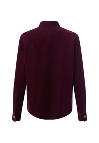 Wino-czerwona koszula z korduroy z długimi rękawami, klasycznym kołnierzykiem i mankietami na guziki; posiada pionowe prążki i zaokrąglony dół.