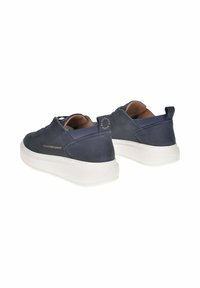 Un paio di sneaker blu navy con suole spesse bianche, marchio dorato "Alexander Smith" e linguette posteriori su sfondo bianco.