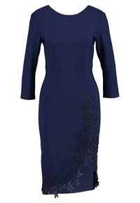 Abito blu navy con maniche a tre quarti, silhouette aderente e dettagli di pizzo floreale intricati lungo il lato sinistro e l'orlo.