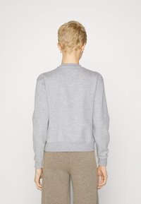 Grå sweatshirt med rund hals, ribbede mansjetter og nederkant. Laget av et mykt, strukturert stoff. Bakutsikt viser et enkelt design uten grafikk.