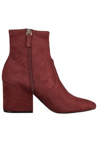 Bottine en daim rouge avec talon bloc et fermeture éclair latérale, bout pointu et détails cousus.