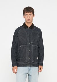 Striped denim jacket with brown corduroy collar, two front pockets, and visible stitching details. Button closure and relaxed fit.