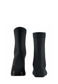 Chaussettes noires avec un motif texturé, présentant de petits points en relief. Poignet côtelé en haut et matériau lisse sur l'ensemble.