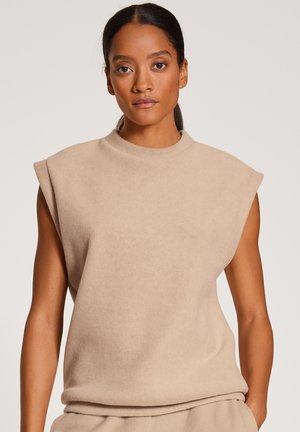Beige, losse mouwloze top met een hoge halslijn en een zachte textuur, voorzien van opvallende schouderaccenten.