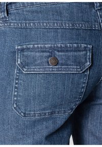 Jean en denim avec un délavage bleu moyen, présentant une poche arrière unique avec un accent de bouton noir rond et des coutures contrastées.
