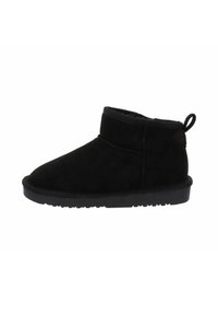 Stivaletto in suede nero con una morbida fodera interna, altezza corta, punta rotonda e una linguetta nella parte posteriore. La suola presenta un design con presa testurizzata.