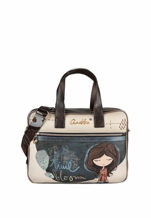 Borsa crema e blu con manici marrone scuro, una tracolla laterale e una bambina dei cartoni animati con gli occhi chiusi e i capelli fluenti stampata sulla tasca anteriore.