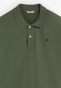 Olivgrünes Poloshirt mit kurzen Ärmeln, zwei Knöpfen auf der Knopfleiste und einem kleinen dunklen Totenkopf- und Knochenlogo auf der linken Brust.