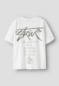 Biała bawełniana koszulka z krótkimi rękawami z zielonym nadrukiem tekstu: "DĄŻ NIE TYLKO DO SUKCESU, ALE DO BYCIA WARTOŚCIĄ" oraz ilustracją królika.