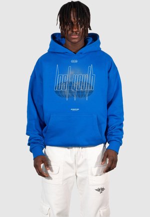 Blue hoodie with a large graphic print that reads "lost youth" in white, featuring a front pocket and ribbed cuffs. Paired with white cargo pants.