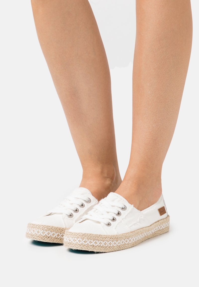 Vita canvas-espadrillos med flätad sula av jute, utrustade med metallöglor och snörning. Prydda med en liten brun logotypmärke.