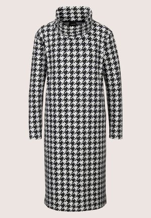 Kleid mit Schwarz-Weiß-Hahnentrittmuster, hohem, gefaltetem Kragen und langen Ärmeln. Aus strukturiertem Stoff, knielanger Schnitt.
