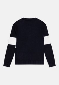 Marineblauer Pullover mit gerippten Bündchen und Saum. Enthält einen auffälligen weißen Streifen über beide Ärmel. Hergestellt aus weichem Strickmaterial.