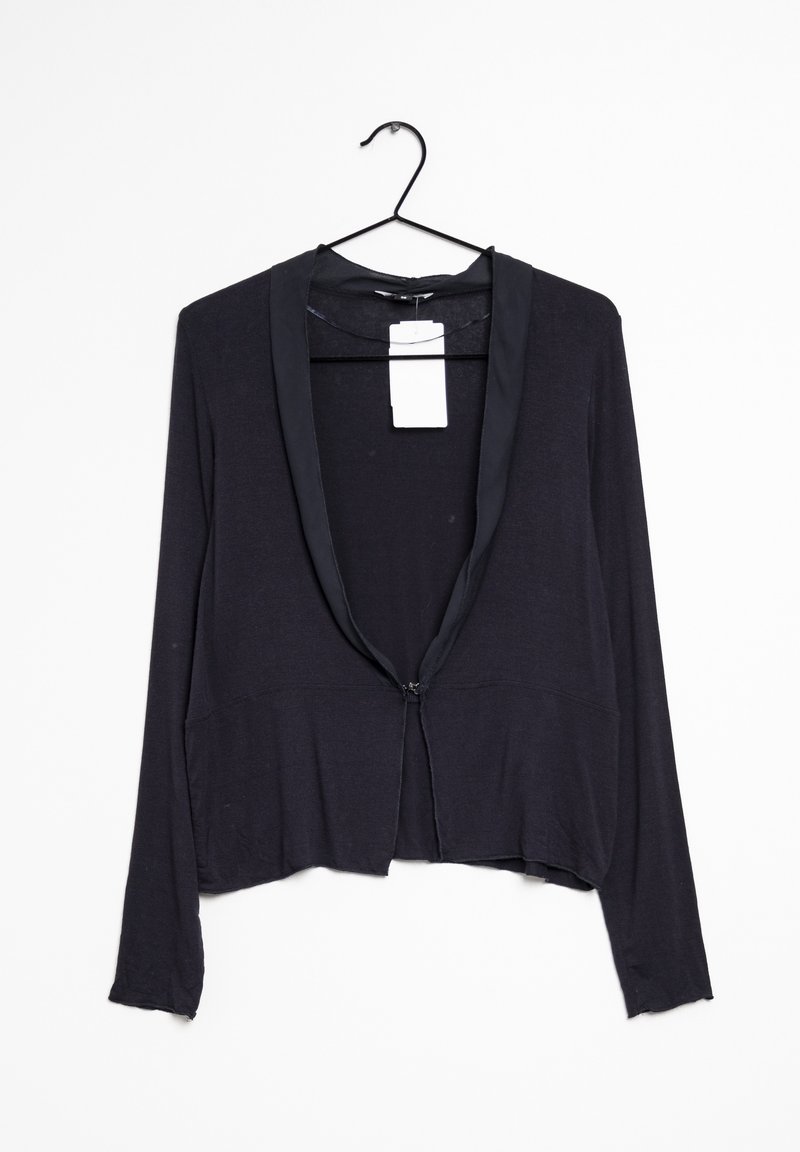 Cardigan noir à manches longues avec revers en satin, suspendu sur un cintre noir contre un fond blanc, étiquette de vente attachée à l'intérieur du col.