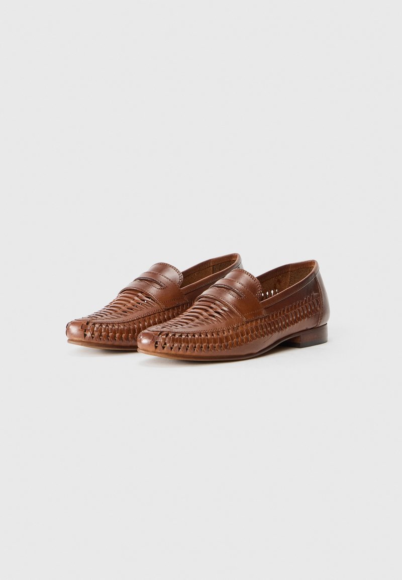 Brown leather loafers featuring woven detailing, rounded toe, and flat heel. Smooth texture with contrasting stitch accents.
