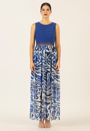Himmelblaue ärmellose Bluse mit einem kontrastierenden gemusterten Maxirock in Blau- und Weißtönen; verfügt über einen elastischen Bund und eine durchscheinende Textur.