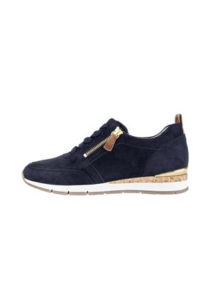 Navy suede sneaker featuring a gold zipper, textured cork midsole, and white outsole. Design includes traditional laces and a sleek silhouette.