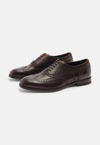 Scarpe brogue in pelle marrone con perforazioni decorative, punta tonda, design con lacci e tacco basso e piatto.