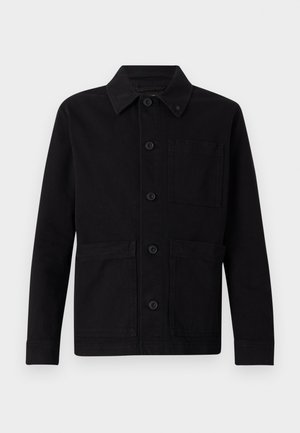 Fekete dzseki gombos elülső résszel, hegyes gallérral, két elülső zsebbel és egyetlen mellzsebbel. Tartós anyagból készült, sima textúrával.