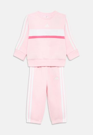 Tuta per bambino di colore rosa chiaro con strisce bianche e rosa scuro, maniche lunghe e logo Adidas sulla maglia e sui pantaloni.
