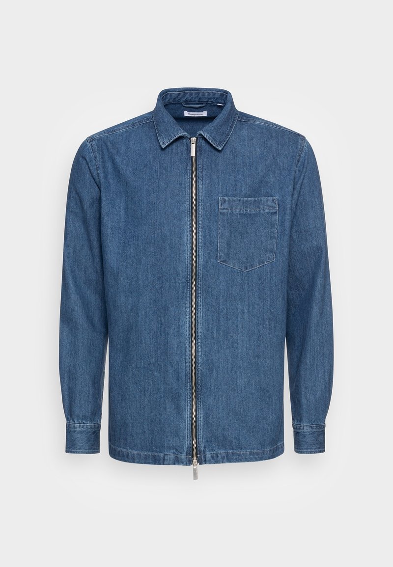 Chemise en denim bleu à manches longues, avec col, poche poitrine avant et fermeture éclair argentée pleine longueur au centre.