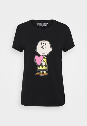 Czarny t-shirt z Charlim Brownem trzymającym różowe serce z neutralnym wyrazem twarzy na jednolitym tle.