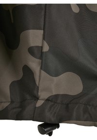 Katonai álcázott minta sötétzöld és szürke árnyalataiban, az alsó szegélyen állítható zsinórral. Simogatós felület.