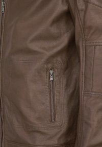 Braune Lederjacke mit strukturiertem Oberfläche, schlanker Passform und einer Reißverschlusstasche auf der linken Seite für die Aufbewahrung.